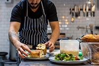A chef plating food in a kitchen